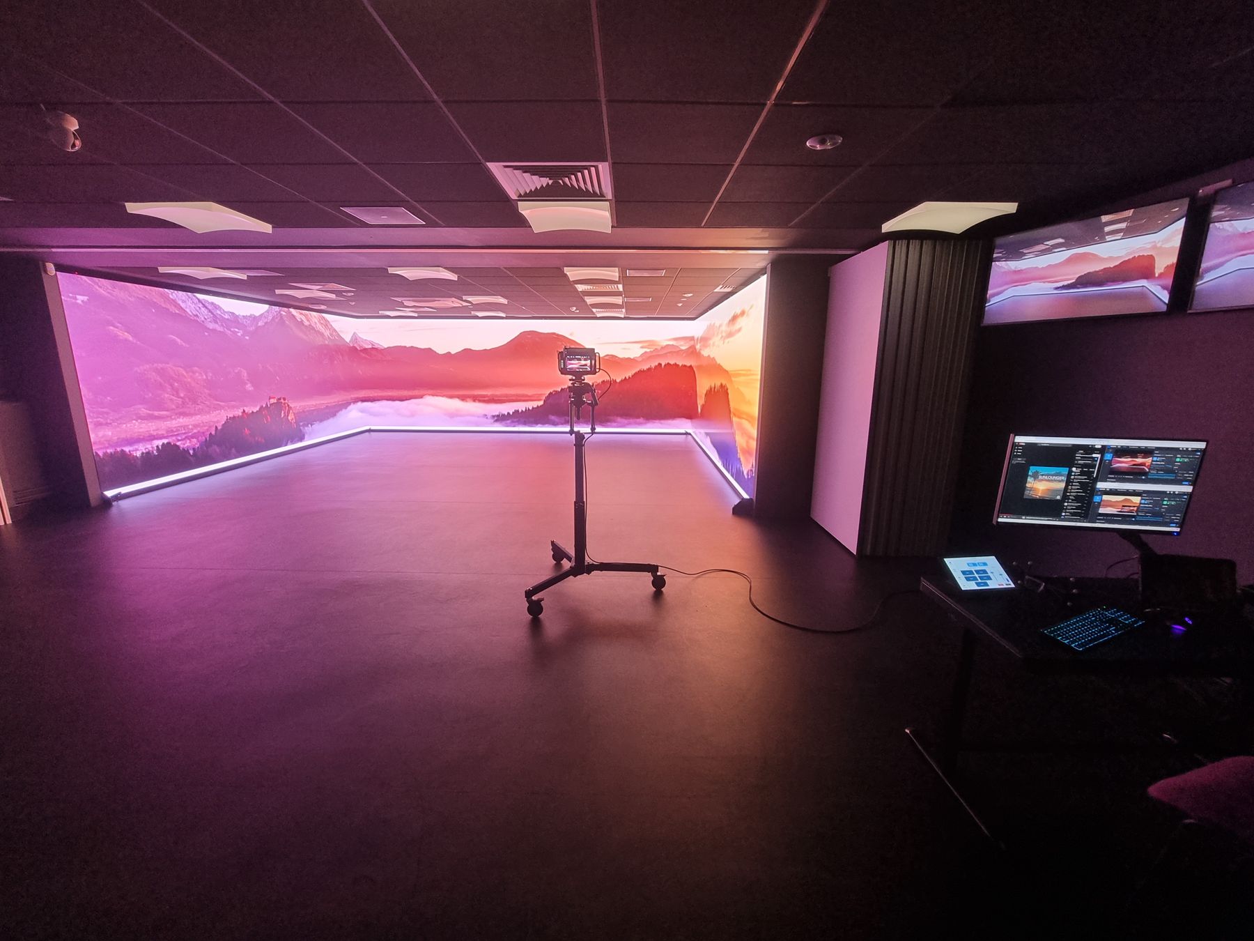 Three-wall LED CAVE at Coventry University showing a mountain landscape across all three walls, with the control desk and touch panel to the right